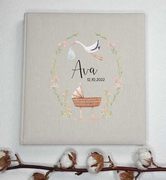 Leinenalbum - Storch mit Babybett und Blumenkranz